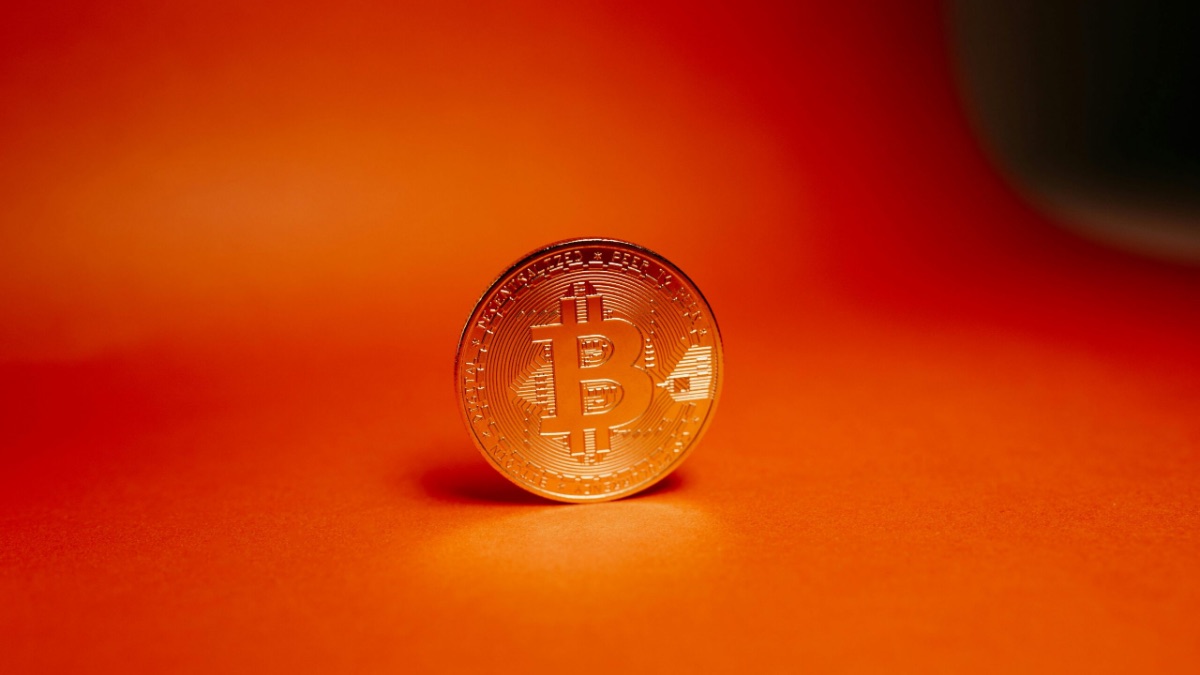 Physical bitcoin coin on orange background